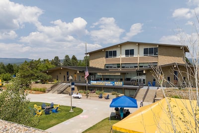 Reed library exterior, with blue and yellow tents and chairs outside.